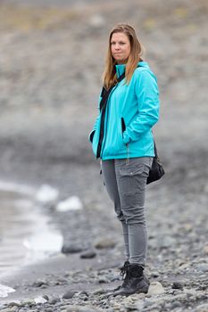 Woman walking over the beach at Jokulsarlon glacier lagoon in southern Iceland