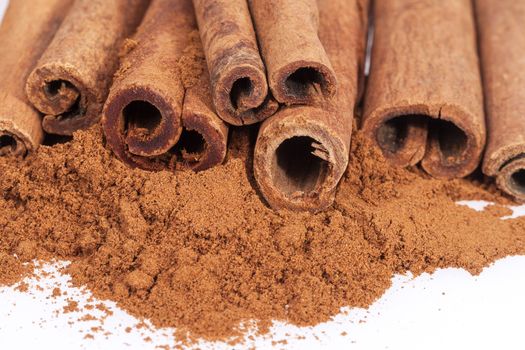 Cinnamon sticks and powder isolated on white background, close up.