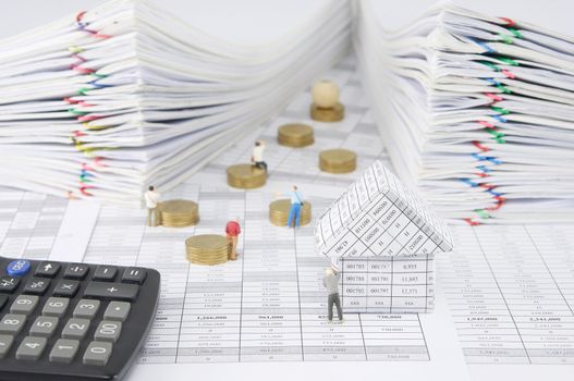 House with photographer on finance account have blur people take photo and pile of gold coins with calculator and pile overload paperwork of report and receipt with colorful paperclip as background.