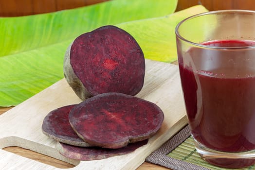 Fresh slices red beetroot and beetroot fruit juice in glass a wood background