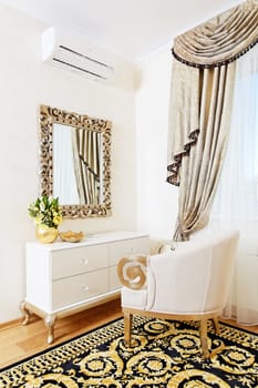 White console-mirror with chair in golden bedroom design