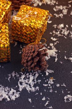 christmas gift boxes with spruce twigs and cones on black