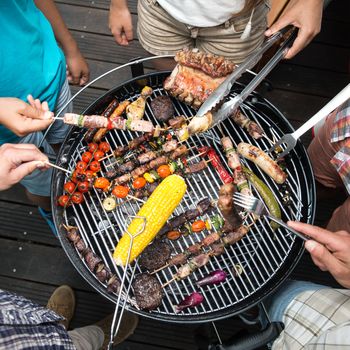 Top view of friend hands serving food at barbecue garden party, France