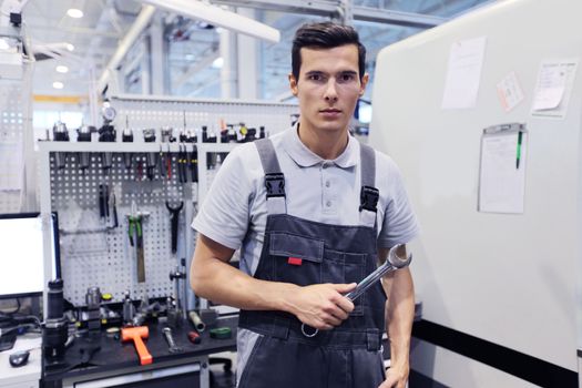 Portrait of a worker with wrench in his shop