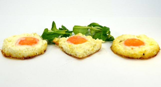 Egg trio on the plate with watercress salad on a white background