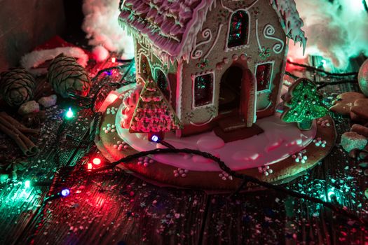 Gingerbread house with lights on dark background, xmas theme