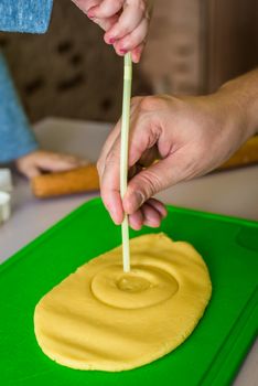 child and dad makes shape of shortcrust dough with straw