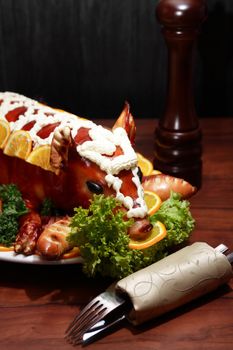 Roast suckling pig decoration with vegetables on big plate