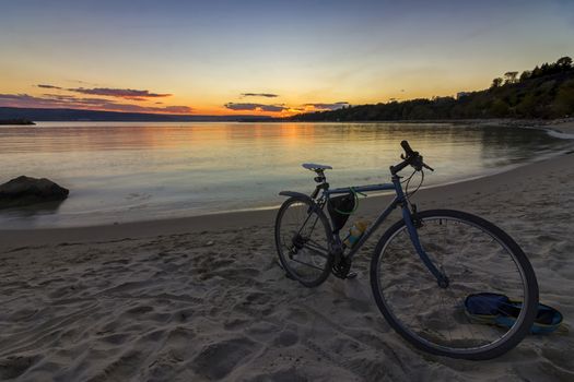 view of bicycle on the shore amid beautiful sunset