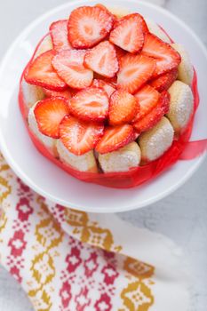 Yogurt strawberry cake with savoiardi biscuits on the table