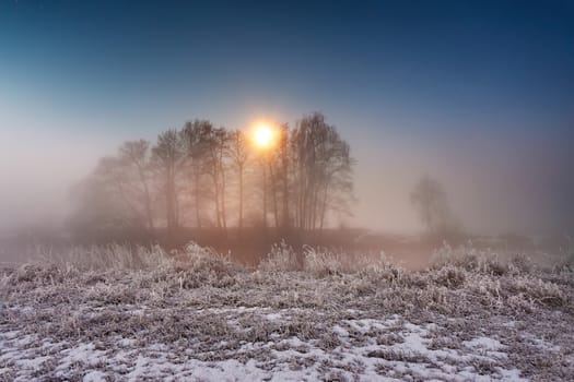 Moonlight in the winter night. Fog and mist on snowy winter river in Belarus.