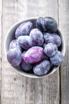 Fresh big plums placed on a wooden table