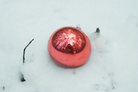 Red Christmas ball on a snowy field, a toy in the snow in the forest