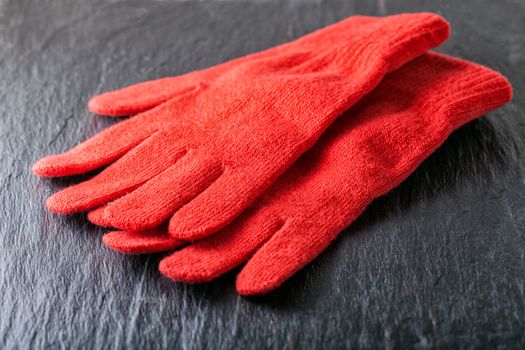 Women's Red gloves placed on black background