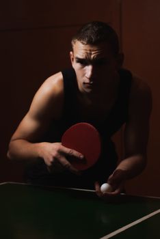 Closeup ping pong, table tennis player, a serious young man in a black shirt, dark atmospheric style