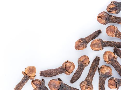Cloves spice on white background with copy space. Isolated one edge. Top view or flat lay.