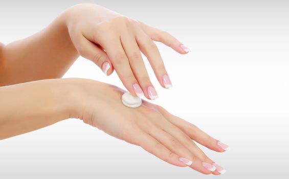 Female hands with a moisturiser on light grey background