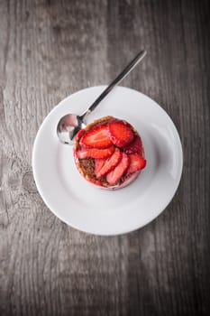 Strawberry and custard tart on a white plate.