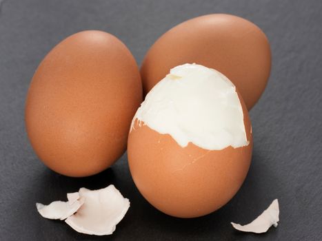 three boiled eggs with egg shell on slate gray background. Close up