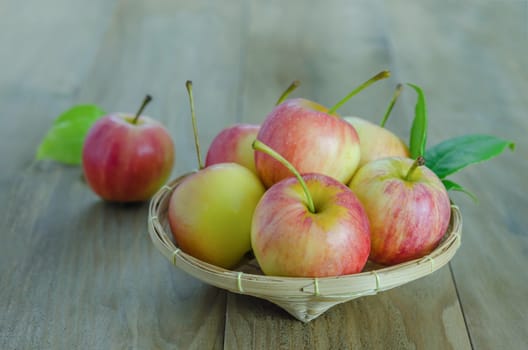 Red and yellow apple  with bamboo basket , organic fresh fruit on wooden background