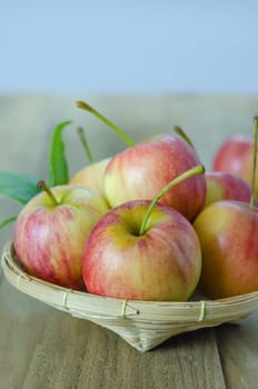 Red and yellow apple  with bamboo basket , organic fresh fruit on wooden background