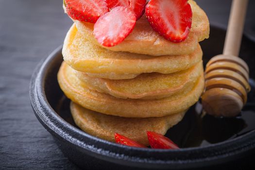 Stack of sweet pancakes with strawberry and honey. Gluten free flour.