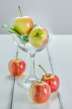 fresh red and yellow apple with glass on wooden background