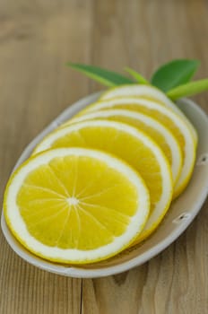 slice orange on dish over wooden background