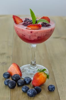 Raspberry smoothie with fresh berries on a wooden table