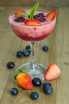 Raspberry smoothie with fresh berries on a wooden table