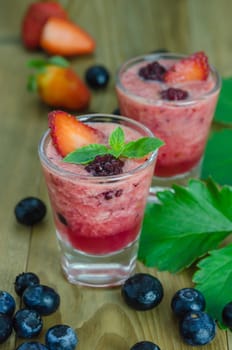 Raspberry smoothie with fresh berries on a wooden table