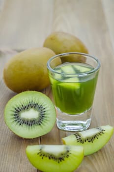 glass of kiwi juice with fresh fruits on wooden table