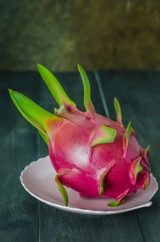 Ripe Dragon fruit  on dish over wooden background , still life