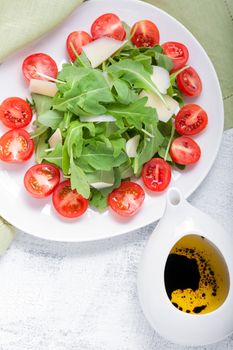 Salad with arugula, tomatoes served on the table