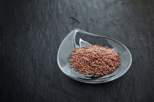 Flax seed in glass bowl a stone plate