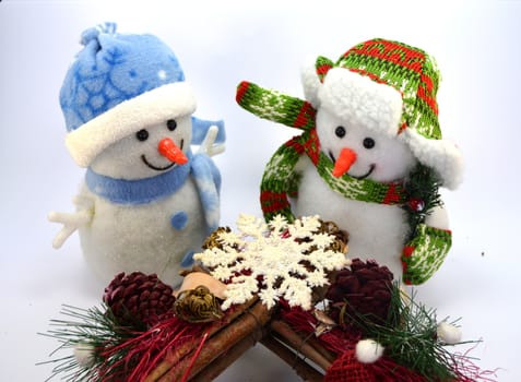 Snowman duo with a snow star and two tassels on white background