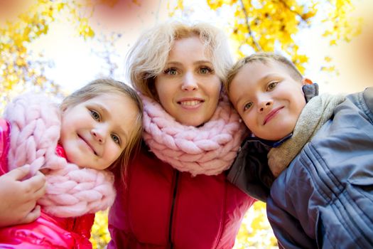 Happy mother and two children looking down in autumn