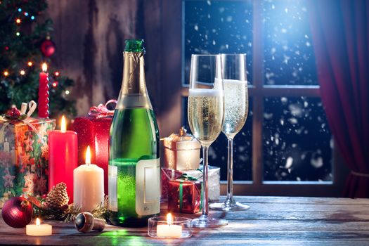 close up view of champagne with candles and gifts on color back