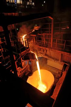 pouring molten steel in steel ladle