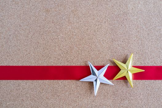 Christmas golden and silver stars and red ribbon on cork board. Christmas pattern.