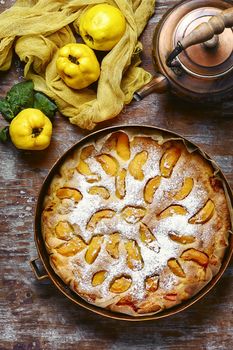 Homemade cake with quince and copper kettle.View top.
