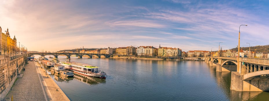 Colorful panorama with the Vltava river, its bridges and the buildings of Prague city, on a sunny day of March.