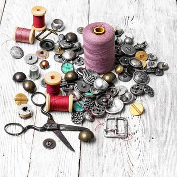 Spools of sewing threads and buttons from clothing