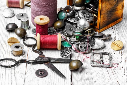 Scattered wooden boxes with iron buttons and sewing thread