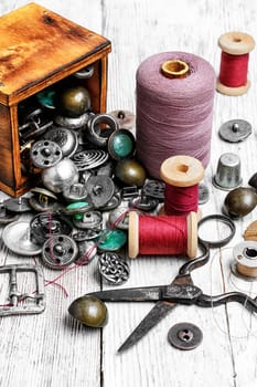 Scattered wooden boxes with iron buttons and sewing thread