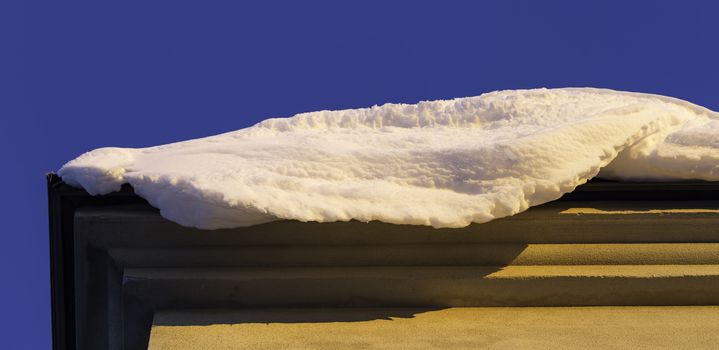 Snow on Edge of Roof with a clear blue sky.