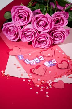 Roses, sheets of paper and letters on a studio background