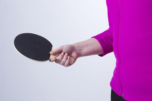 Active senior woman playing table tennis in front of white background