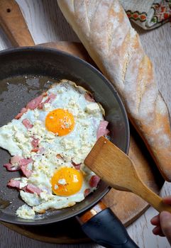 Fried eggs in a frying pan and homemade bread