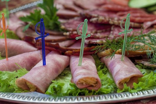 tasty meat rolls with ham and cheese and greens